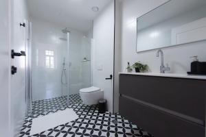 a bathroom with a shower and a toilet and a sink at PORT CITY HAIFA - Authentic German Colony Apartments in Haifa