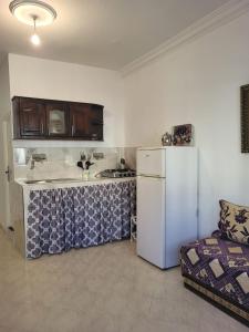 a kitchen with a white refrigerator and a couch at Appartement Tanger 2 in Tangier