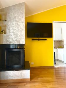 a living room with a fireplace and a yellow wall at Yellow House in Teramo