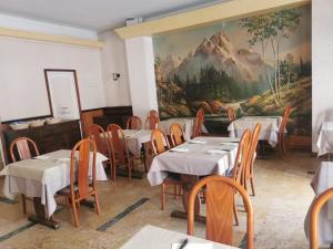 een eetkamer met tafels en stoelen en een muurschildering bij hotel le tourisme in Embrun