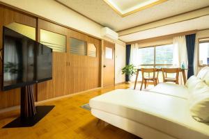 een woonkamer met een bank en een flatscreen-tv bij Furano - House / Vacation STAY 56483 in Furano