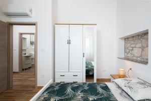 1 dormitorio con 1 cama y armario blanco en Villa Dana, en Banjole