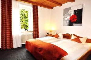 Un dormitorio con una cama grande y una ventana en Seehotel Schlierseer Hof en Schliersee