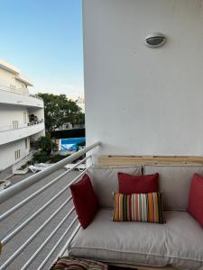 a couch sitting on a balcony with red pillows at Cozy Apartment in Santa Luzia