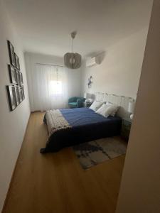 um quarto com uma cama com um cobertor azul em Cozy Apartment em Santa Luzia