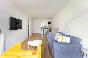 a living room with a blue couch and a table at Cityscape in Noisy-le-Grand