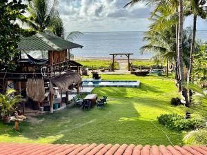 a resort with a swimming pool next to the ocean at JaParaíso Pousada Ateliê in Japaratinga