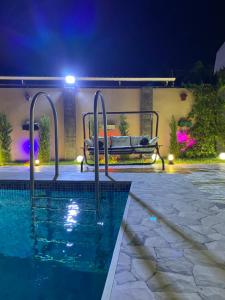 a swimming pool at night with a bench next to it at Elite Novkhany-Corat Villa in Corat