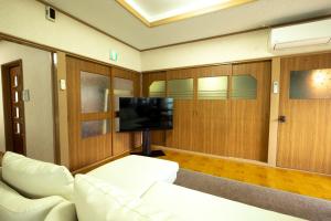 een woonkamer met een witte bank en een flatscreen-tv bij Furano - House / Vacation STAY 56483 in Furano