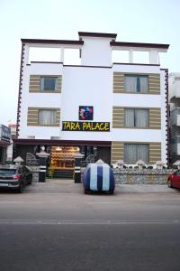 Un gran edificio blanco con un gran colchón delante. en HOTEL TARA PALACE, en Puri