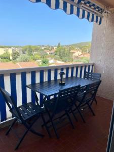 d'une table bleue et de chaises sur un balcon avec vue. dans l'établissement Spacious and bright cocoon near the sea, à Bandol