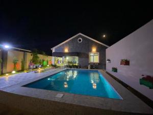 a swimming pool in front of a house at night at Elite Novkhany-Corat Villa in Corat