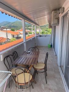 a patio with tables and chairs on a balcony at House Filippos in Sarti