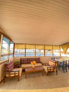 a living room with a couch and chairs and tables at Blue Sky Apartment Paralia in Paralia Katerinis