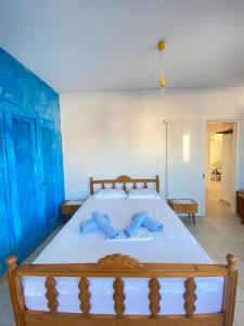 a bedroom with a large bed with blue pillows at Blue Sky Apartment Paralia in Paralia Katerinis