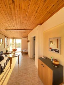 a living room with a wooden ceiling and a table at Blue Sky Apartment Paralia in Paralia Katerinis +26 photos