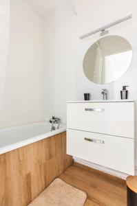 a bathroom with a tub and a sink and a mirror at Cityscape in Noisy-le-Grand