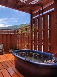 a large tub sitting on a wooden deck with a patio at Masutomi Ryokan in Hakone