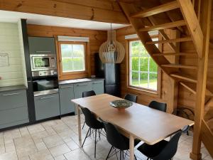 cocina con mesa de madera y sillas en Vrijstaande luxe Finse blokhut 2-6 of 2-8 pers, en Kropswolde