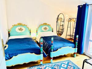 two beds in a room with blue and white at Yellow House in Teramo