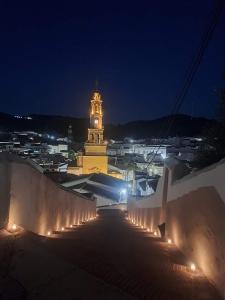 ein Gebäude mit einem Uhrturm in der Nacht in der Unterkunft Balcón de la Moreria con alberca in Constantina