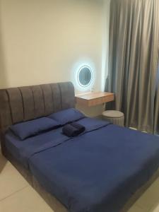 Schlafzimmer mit einem Bett mit blauer Bettwäsche und einem Schreibtisch in der Unterkunft Majestic maxim 3 bedrooms link MRT cheras Kuala lumpur in Cheras