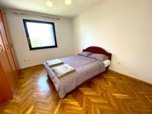a bedroom with a bed and a window at Apartman Akvamarin in Vrnjci +2 photos