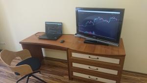 a desk with a television and a laptop on it at Apartments "The cultural capital" in Lviv