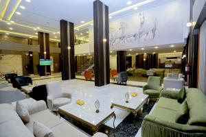 a lobby with couches and tables in a building at Tulip Plaza Hotel in Hafr Al Baten