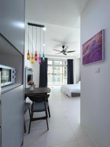 a living room with a dining room table and a bedroom at Cozzzy hut @ Riverine Diamond Kuching in Kuching
