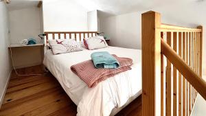 une chambre avec un lit avec des draps blancs et des oreillers roses dans l'établissement Loire Nature, proche de la ville, à Orléans