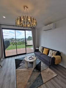 sala de estar con sofá y ventana grande en Paradise Retreat en Tauranga