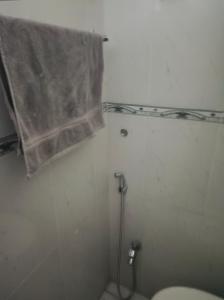 Un baño con inodoro y cortina de ducha. en Khaqan Heights, Murree, en Murree 4 fotos más