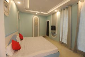 Mandav Hills Resort & Film City في Māndu: غرفة نوم عليها سرير ومخدات حمراء