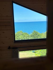 uma janela numa cabana com vista para o oceano em Casa di Arte Wood House em Perşembe