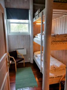 Cette chambre comprend 2 lits superposés et une fenêtre. dans l'établissement Stor super leilighet - bakkeplan - barnevennlig - 80m2 - selvhushold - vaskefirma, à Hovden