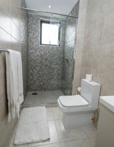 a bathroom with a toilet and a shower with a window at LeR Homes in Nairobi