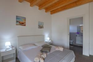 - une chambre avec un lit blanc et des serviettes dans l'établissement Allu ruvezzu 2.0, à Torre Mozza