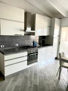 a kitchen with white cabinets and a stove top oven at SGC Boa Vista Apartments in Sal Rei