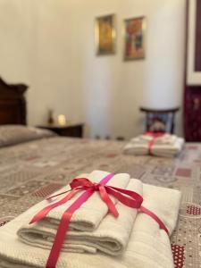 un paio di asciugamani con un nastro su un letto di Civico 11 Holiday Home a Collepasso