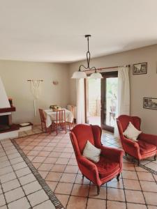a living room with two red chairs and a table at Mosè House in Formia