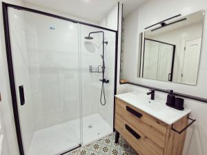 y baño con ducha, lavabo y espejo. en MONFORTE CENTRO APARTAMENTO, en Monforte de Lemos