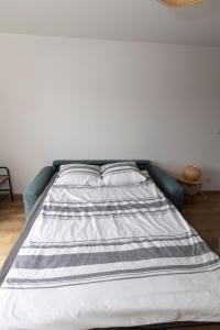 a bed in a bedroom with a striped mattress at Le paille en queue in Sainte-Mère-Église