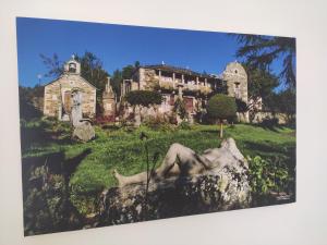 Una foto de una casa con una estatua delante de ella. en A Casiña do Camiño, en Baamonde