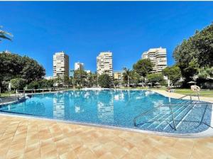 a large swimming pool with a city in the background at Apartamento primera linea playa in Torremolinos