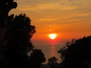 um pôr-do-sol sobre o oceano com o sol no céu em Amvrosia Apartments em Mastihari