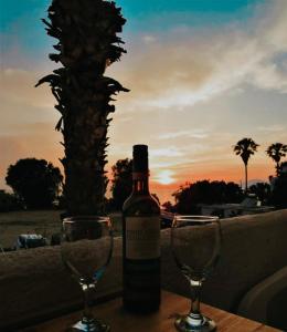 a bottle of wine sitting on a table with two glasses at Amvrosia Apartments in Mastichari