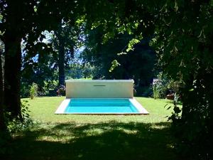 a pool in the middle of a field with trees at la maison de Manon in Mirande