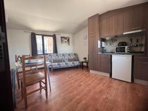 een keuken en een woonkamer met een bank en een tafel bij Apartaments ENGAIT in Pas de la Casa