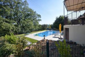 ein Pool in einem Garten mit einem Zaun in der Unterkunft Villa La Couaste in Lorgues